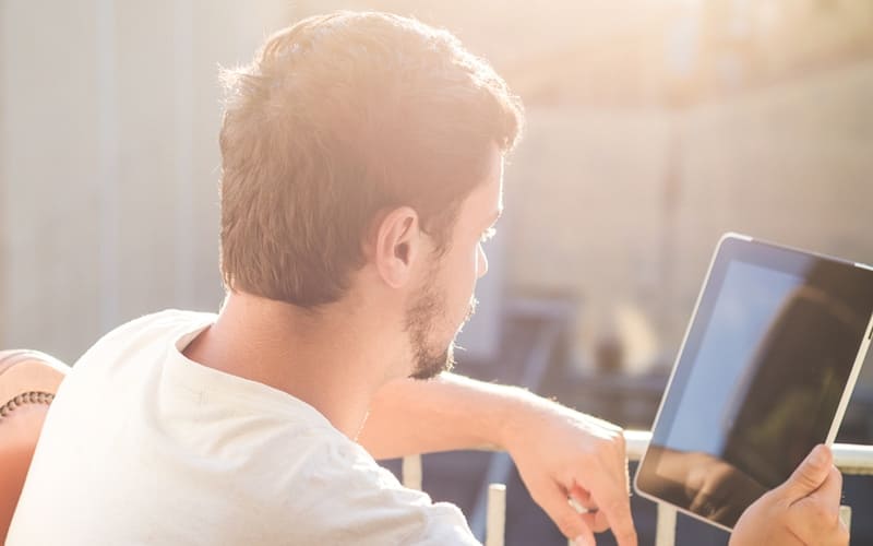 Man with bad credit looking at debt consolidation loan on tablet