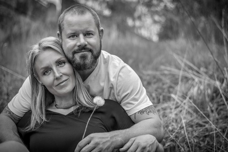 Adult couple sat in a grass field