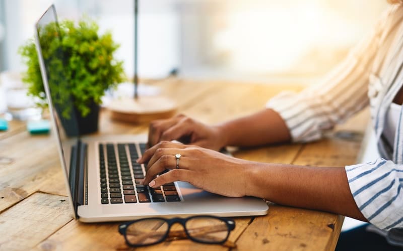 Person looking up debt consolidation loans on laptop