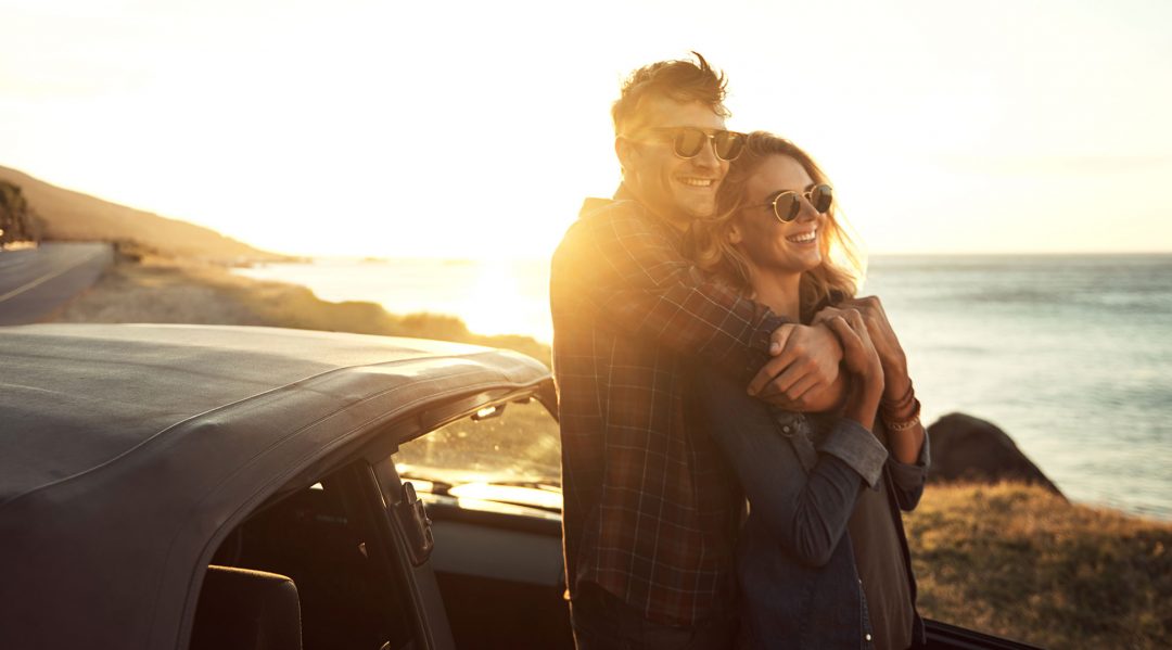 Couple next to a car they bought with a personal loan